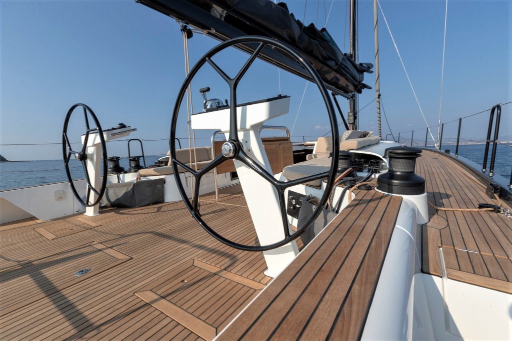 The deck space of a sailing boat with a command area and a small refreshment area