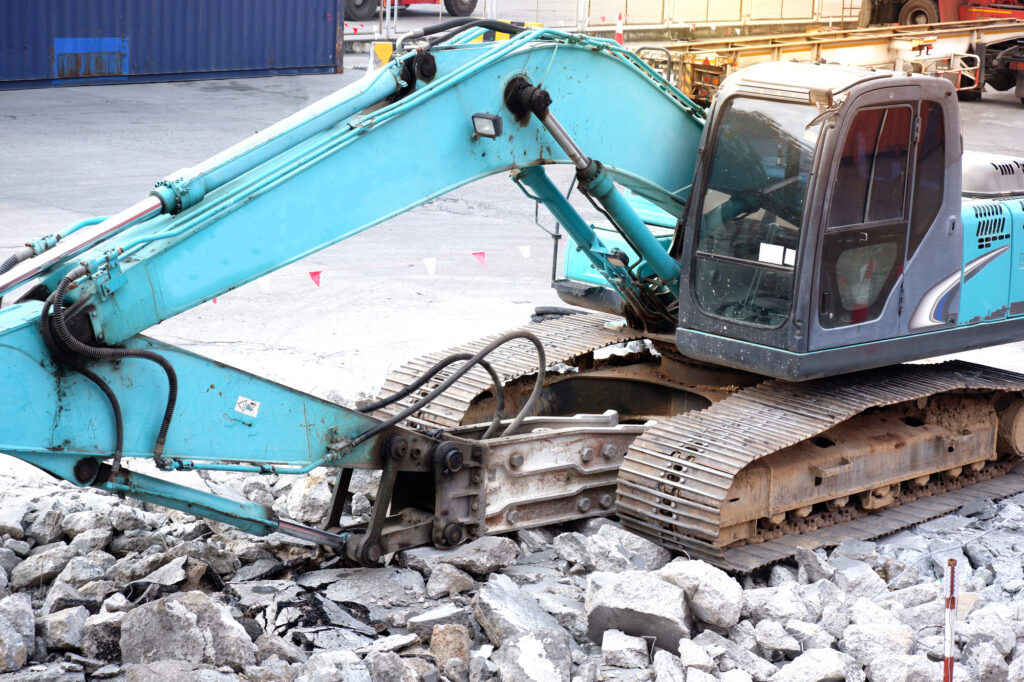 Escavatore da roccia al lavoro per demolire il calcestruzzo